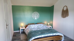 A bedroom with a bed, two bedside lamps, a wall art piece, and a woven wall hanging. - Relaxation on the banks of the Loir, Gîte2 (Les Roches L'Evêque)