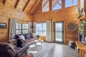 Relax in this inviting living room with a comfortable sofa, armchair, and stone fireplace.