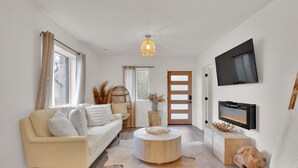 A modern living room with a sofa, coffee table, and a fireplace.
