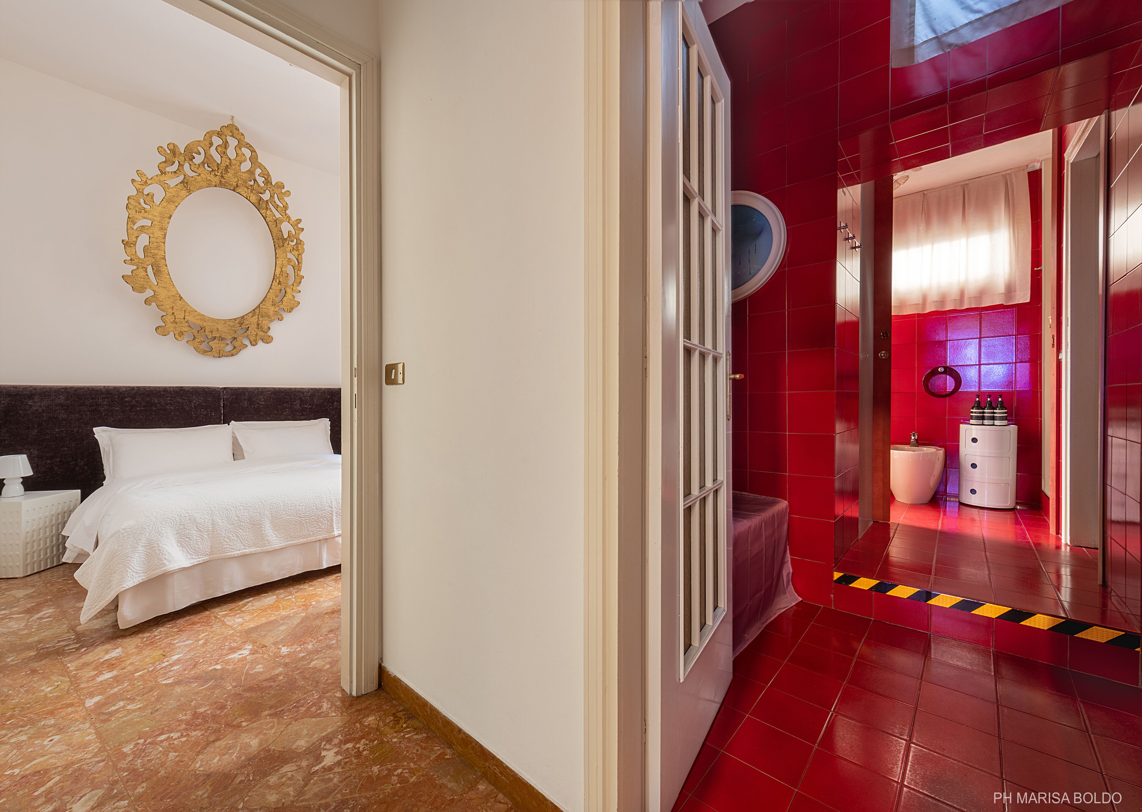 A hotel room with a bed, a bedside table, and a wall-mounted mirror.
