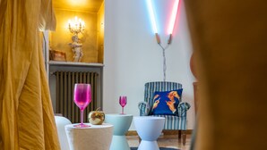 A modern living room with a sofa, a coffee table, and a chair. There is a lamp and a decorative item on the wall. - Billie's Flat RED - art & design apt in Verona historic centre (Verona)