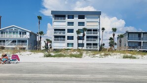 A beachfront hotel with multiple floors, balconies, and palm trees. - LIVE ON THE BEACH. Gulf Beach Front - Spectacular views. (Indian Shores)
