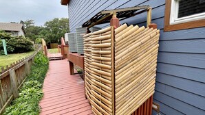 Een houten terras met een bamboe hek en een rode looppad.
