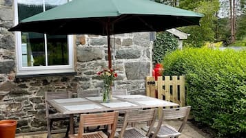 Relax in a serene outdoor space with a seating area, complete with a wooden table and comfortable chairs.