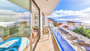 A balcony with a pool, chairs, and a bed. - Villa Marni - Six Bedroom Villa, Sleeps 12 (Kalkan)