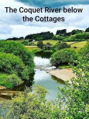 A river flowing through a lush green landscape with cottages in the background. - Stone built cottage, comfortably sleeps up to 6.<br> <br>Ideal for holiday makers who love to explore! (Morpeth)