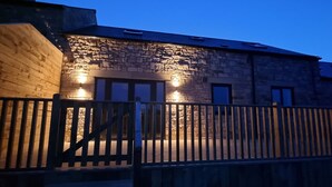 A stone building with a wooden fence and steps leading up to the entrance. - Comfortable, modern cottage that sleeps up to 6. Ideal hub to explore Northumberland! (Morpeth)