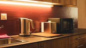 Una cocina con una tetera, un tostador y un microondas en la encimera.