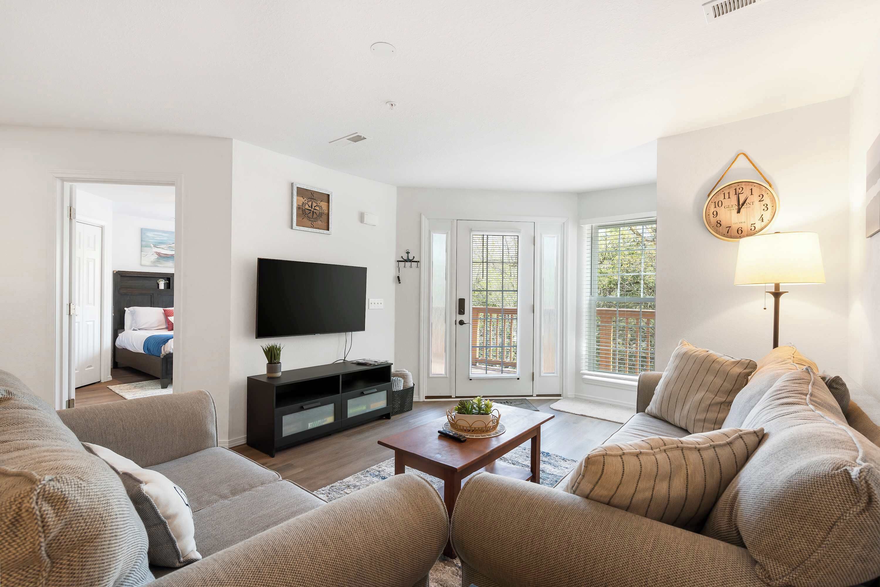 A living room with a flat-screen TV, a coffee table, and a sofa.