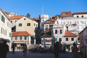 A historic town square with buildings, a clock tower, and a flag. - Pool Villa Luxoria Trebesin (Herceg Novi)