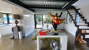 A modern interior with a staircase, a red box on a table, and a decorative sculpture. - VILLA COMBINES MODERNITY AND STONES. IDEAL FOR FAMILY OR WORK (LIFFRE)