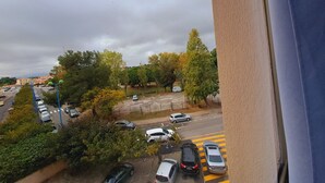 A parking area with multiple cars, trees, and a distant view of buildings. - Lovely studio overlooking the Alberts at the port, with the sea in front (Saint-Cyprien)