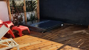 A wooden deck with a trampoline and red plastic chairs. - VILLA WITH JACUZZI (cers)