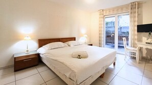 Una camera d'hotel con un letto, comodini, una scrivania e una televisione.