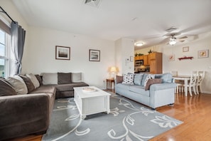 Relax in this stylish living room with a brown sofa, light blue sofa, and a dining area.