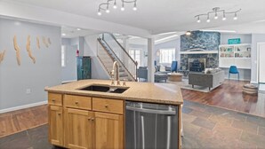 A spacious kitchen with a central island, wooden cabinets, and a stainless steel dishwasher. - Lake Therapy On Keuka | Lakefront | FLX | Hot Tub (Branchport)