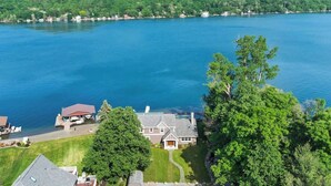 A lakeside property with a large house, a dock, and a well-maintained lawn. - Lake Therapy On Keuka | Lakefront | FLX | Hot Tub (Branchport)