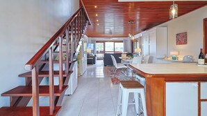 Una cocina amplia con una escalera de madera, un comedor y vistas al exterior.