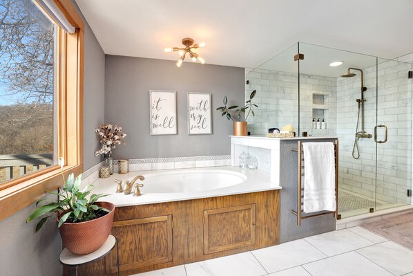 A modern bathroom with a large sink, wooden cabinetry, a glass shower enclosure, and decorative wall art. - Log Home on Beaver Lake, Big Views, Big Fun!! (Springdale)