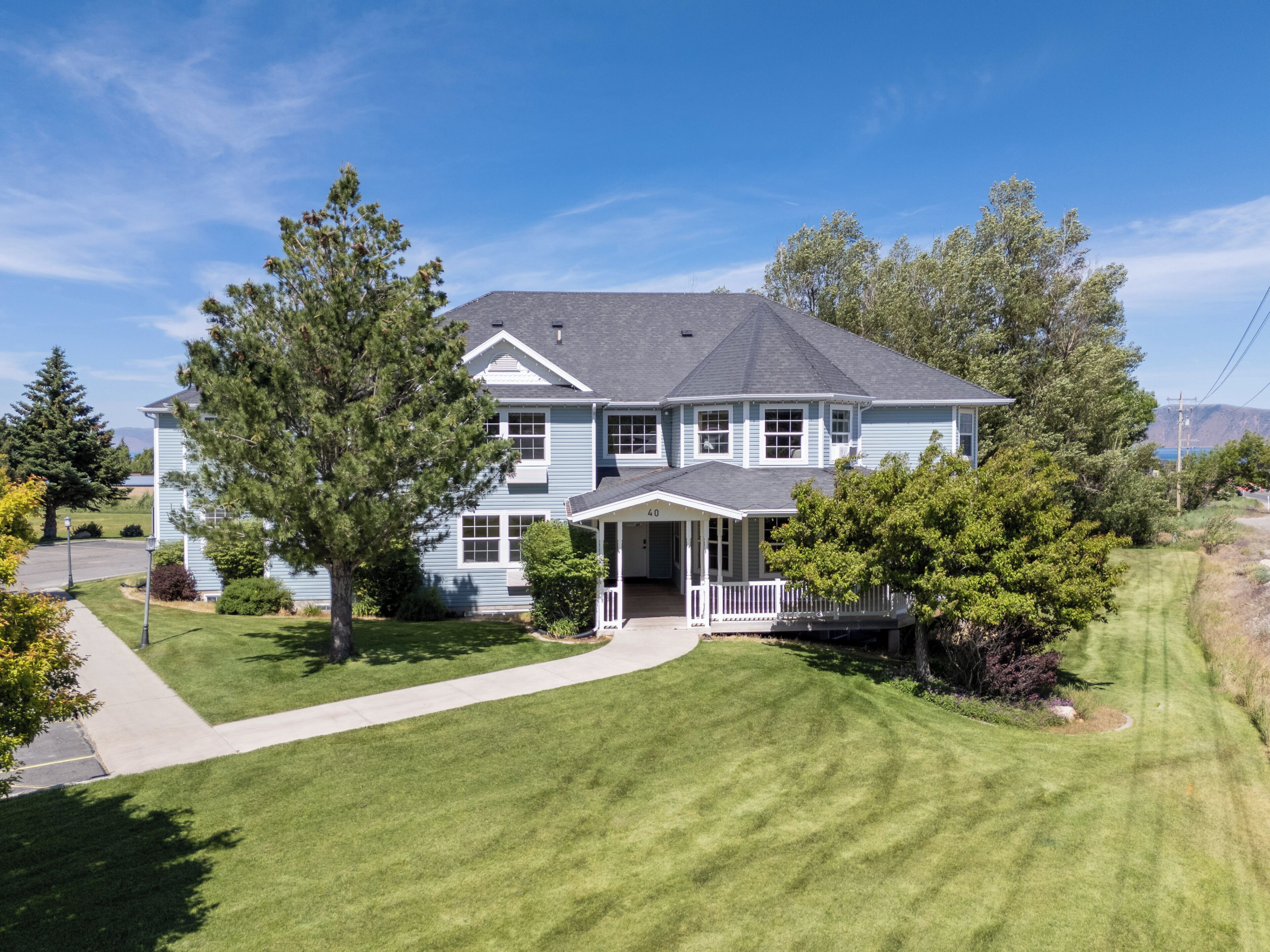 A two-story house with a front porch and a well-maintained lawn.