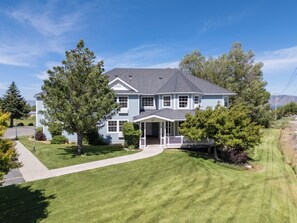 A two-story house with a front porch and a well-maintained lawn.