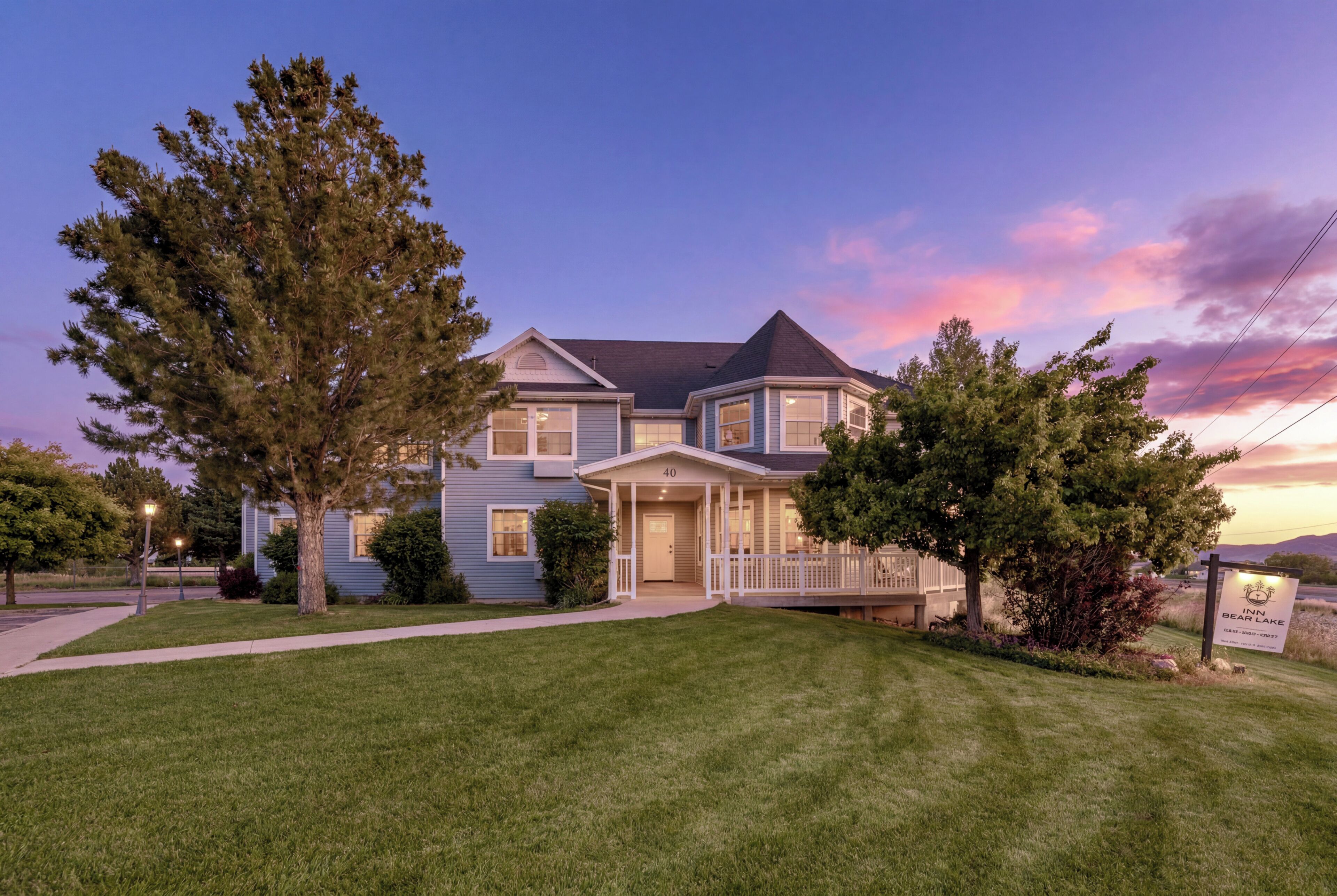 A two-story house with a front porch and a well-maintained lawn.
