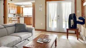 Een woonkamer met een bank, salontafel en een televisie op een dressoir.