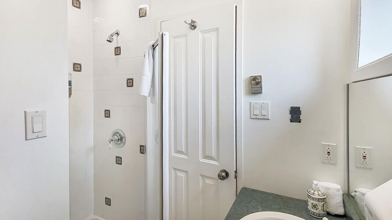 Een badkamer met een douche, toilet en wastafel.