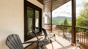 Un balcon avec deux chaises, une table et une vue sur un paysage montagneux.
