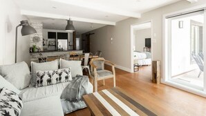 Un salon moderne avec un canapé, des fauteuils et un coin repas.