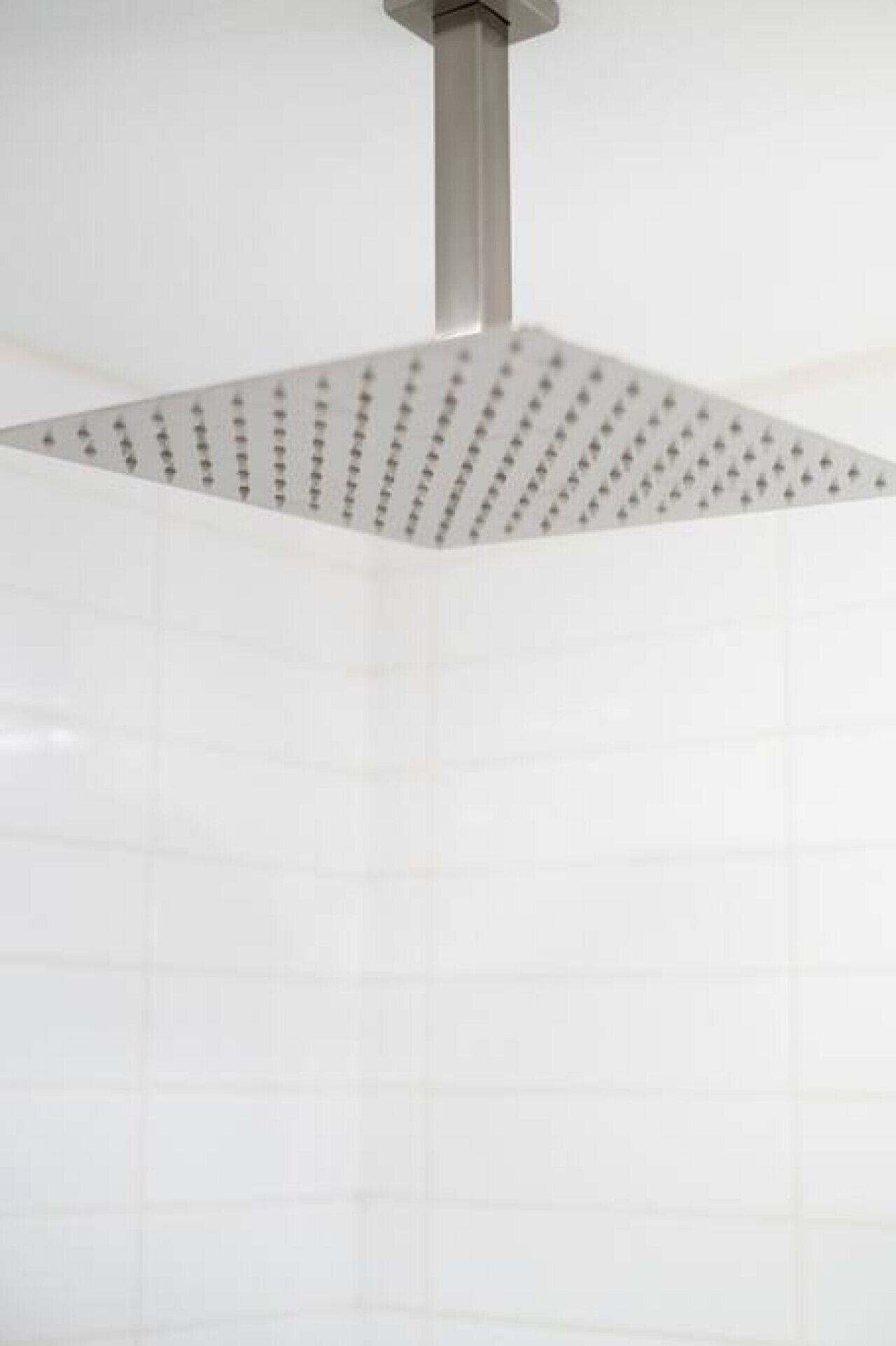 Une douche avec un plafond carré et perforé.