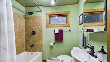 Un baño con bañera, inodoro y lavamanos.