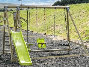 A playground with a slide, swings, and a ladder. - A fabulous place to come and make memories whatever the occasion. (Stanhope)