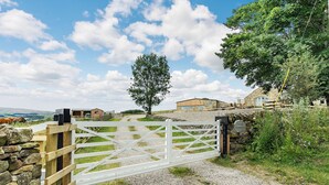 A rural property with a gravel path leading to a white gate, stone walls, and a large tree. - A fabulous place to come and make memories whatever the occasion. (Stanhope)