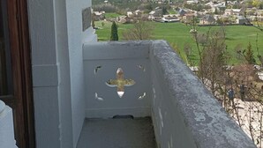 A balcony with a view of a mountainous landscape and a village below. - 2nd floor, swimming pool, hammam, terrace, balcony, parking, tv, 55m², Pra Loup (Jausiers)