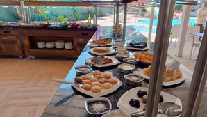 A buffet with various food items and serving utensils. - UK Hotels Kiriş (Kemer)