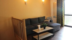 A living room with a sofa, a coffee table with a plant, and two wall-mounted lights. - Floor -2, view valley, swimming pool, hammam, terrace, parking, tv, 50m², Pra Loup (Jausiers)