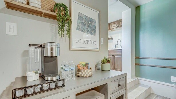 A kitchen with a coffee maker, water bottles, and a framed map of Colorado. - Institute Bliss! Newly Remodeled Family Home! (Colorado Springs)