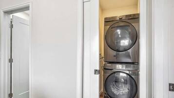 Une buanderie équipée de deux machines à laver à chargement frontal superposées.