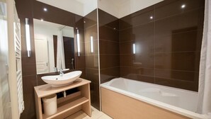 A modern bathroom with a large sink, mirror, and bathtub. - 1st floor, swimming pool, hammam, terrace, parking, tv, 27m², Pra Loup (Jausiers)