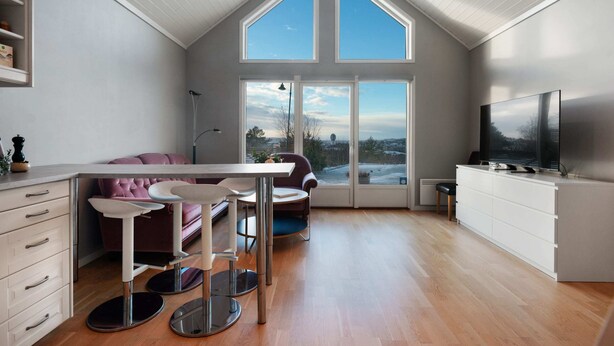 A modern kitchen with a dining area, large windows, and a TV. - Sea-View Anexet in Fjällbacka by AJF Dream Living (Fjällbacka)