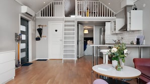 A spacious loft-style apartment with a mezzanine, open kitchen, and a dining area. - Sea-View Anexet in Fjällbacka by AJF Dream Living (Fjällbacka)