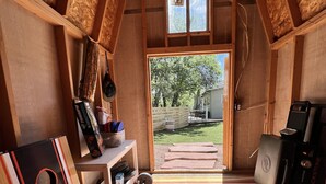 Un cuarto ático acogedor con techo inclinado, un ventanal y vista a un patio trasero.