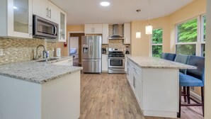A modern kitchen with a central island, stainless steel appliances, and a view to the outside. - Holiday Home Near Lake and Pool (Tobyhanna)