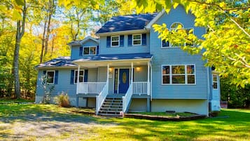 A two-story house with a front porch and a small front yard.
