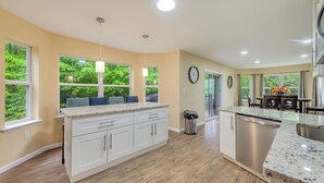 A modern kitchen with white cabinets, a stainless steel dishwasher, and a granite countertop. - Holiday Home Near Lake and Pool (Tobyhanna)
