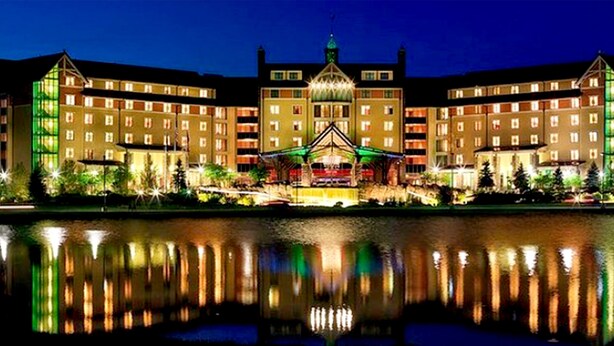 A large hotel with multiple floors, a central courtyard, and a reflection in the water. - Holiday Home Near Lake and Pool (Tobyhanna)