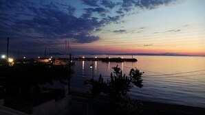 Un puerto deportivo al atardecer con barcos amarrados, agua tranquila y cielo despejado.