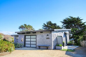 Una casa moderna de un solo piso con garaje, un pequeño patio y el número 5768 en la puerta.