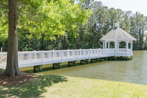 A gazebo on stilts over a body of water, surrounded by trees.